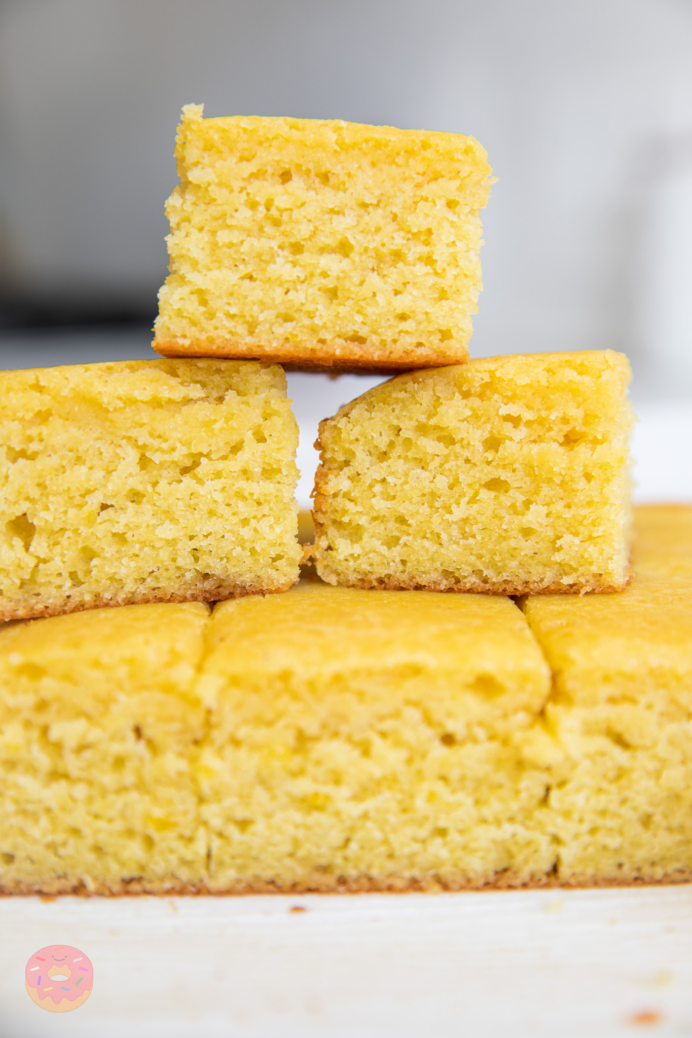 Stack of moist homemade cornbread squares on a platter, tender and buttery