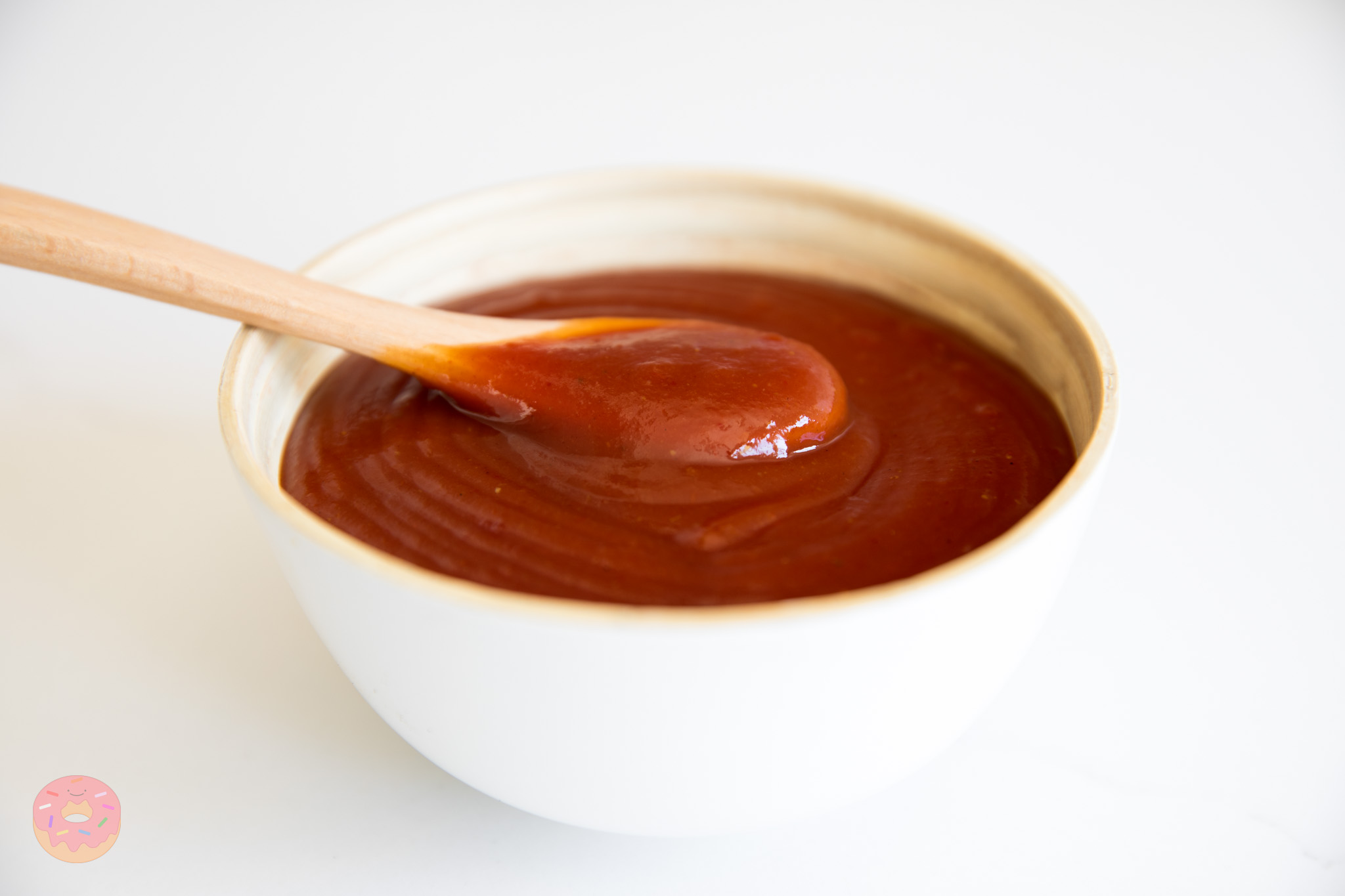 Thick homemade barbecue sauce being spooned in a bowl, rich tangy BBQ sauce made from scratch
